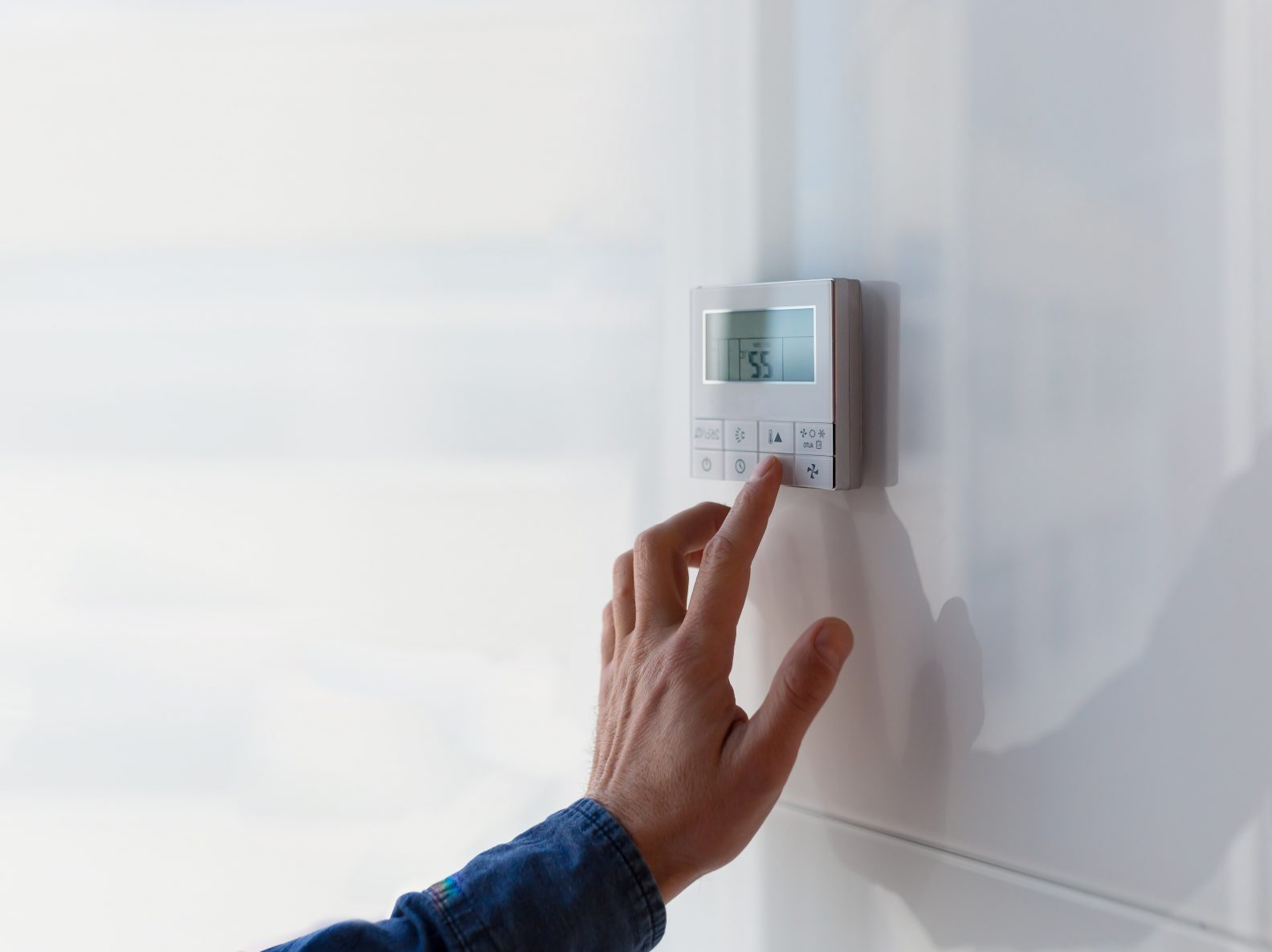Régulation d'air The air conditioning and heating control panel for office is located on a white wall